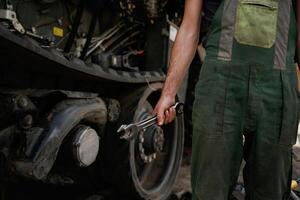Holding wrench., Mechanic's hand fixing machinery in workshop photo