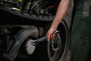 Holding wrench. Mechanic's ,hand fixing machinery in workshop photo