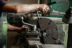 Side view., Close-up of worker's hands operating industrial machinery in workshop photo