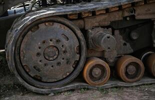 Close-up of old rusty tank tracks with dirt and grime photo