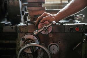 Busy man. Close-up of ,,worker's hands operating industrial machinery in workshop photo