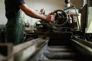 Side view. Close-up of worker's ,,hands operating industrial machinery in workshop photo