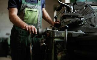Side view. .Close-up of worker's hands operating industrial machinery in workshop photo