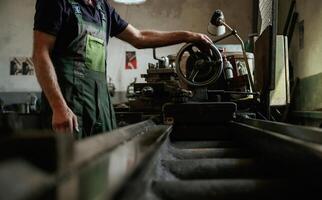 Side view. Close-up of, worker's hands operating industrial machinery in workshop photo