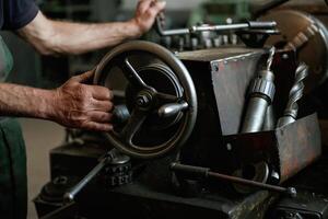 Close-up of worker's hands, operating industrial machinery in workshop photo