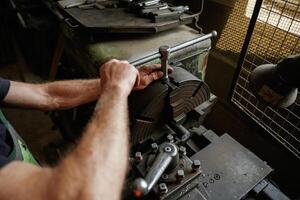 Focused view. Close-up, of worker's hands operating industrial machinery in workshop photo