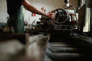 Side ,view. Close-up of worker's hands operating industrial machinery in workshop photo