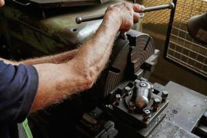 Busy ,man. Close-up of worker's hands operating industrial machinery in workshop photo