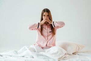 Rest ,conception, waking up, on, the white blanket. Young pretty woman is against background in the studio photo
