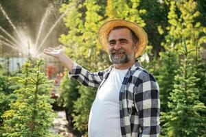 Showing the ,,automatic watering machine. Senior gardener is at work at daytime photo