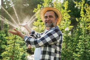 Showing, the automatic watering machine. Senior gardener is at work at daytime photo