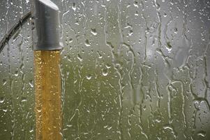 Raindrops run down a window, creating a beautiful abstract and watery scene. photo