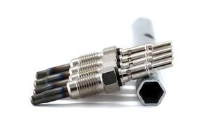 Automotive glow plugs with a wrench isolated on white background, detailed mechanical view. photo