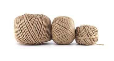 Close-up shot of three different sized balls of brown twine, isolated on a white background. photo