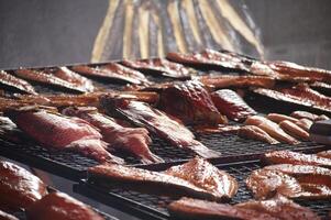 An assortment of smoked fish on a grill rack offers a delectable culinary experience. photo
