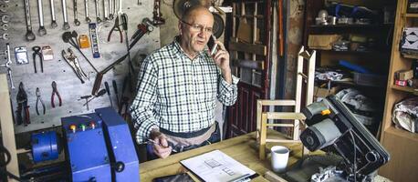Carpenter talking with phone in his workshop photo