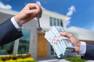Man Handing a man Thousands of Dollars For Keys in Front of House. photo