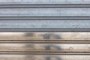 Weathered metallic shutter with horizontal lines photo