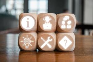 Wooden blocks with icons representing help desk concepts like information, support, teamwork, innovation, tools, and solutions. photo