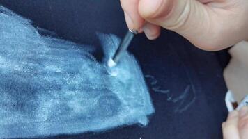 Artistic process of applying chalk paint on fabric by female artist using brush techniques in closeup, 4k. video