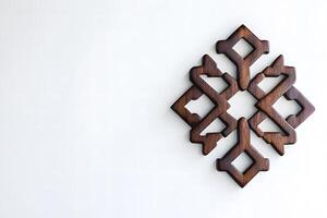 Intricately Carved Wooden Ornament Against a Minimalist Background Highlighting Unique Design Elements and Craftsmanship Showcased in Contemporary Decor photo