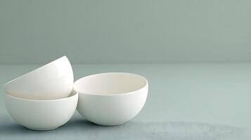 Elegant minimalistic composition of three white ceramic bowls artfully arranged on a serene pastel background emphasizing simplicity and modern design aesthetics photo