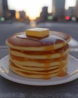 A Delicious Stack of Fluffy Pancakes with Butter and Maple Syrup Against a Soft Sunset Background in an Urban Setting photo