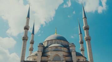 Majestic Architecture of a Historic Mosque Under a Blue Sky with Clouds and Elegant Minarets Reaching Toward the Heavens, Symbolizing Cultural Significance and Spirituality photo
