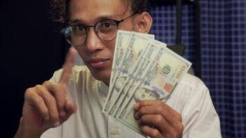 A man is recommending credit card payments, showing several hundred dollars and a credit card alternately with his hands. business and financial concept video