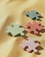 A puzzle piece laying on a beach photo