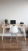 A white chair and a laptop on a wooden desk photo