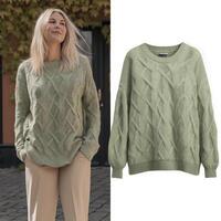 A smiling woman in green cable knit sweater stands outdoors, paired with separate image of sweater on white background photo