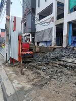 An excavator performs excavation work with unwavering determination, showing strength and precision in urban landscape photo