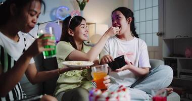 Handheld shot, Three young women chatting happily, enjoying snacks and drinks at their small party. video
