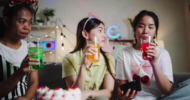 Handheld shot,Three young women chatting happily, enjoying snacks and drinks at their small party. video