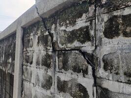 A crack wall concrete damage block texture surface pattern weathered old building broken structure cement aged exterior background architecture construction fracture flaw imperfection defect failure photo