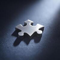 Single puzzle piece shines against dark surface, evoking feelings of incompleteness, problem solving, and need for connection photo