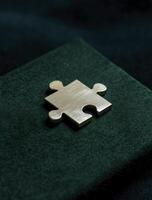 Single gold puzzle piece rests confidently, symbolizing completeness and hinting at satisfaction of perfectly solved challenge photo