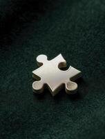 Single gold puzzle piece sits alone, representing concept of being incomplete yet full of potential. It evokes sense of quiet contemplation photo