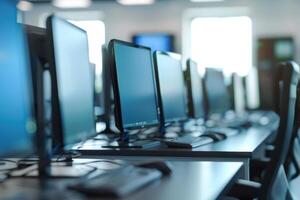 A row of computer monitors in a classroom photo