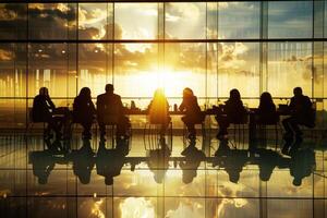 Silhouette of business people sitting at a table in front of a window photo