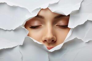 A woman's face peeking out of a hole in a paper photo