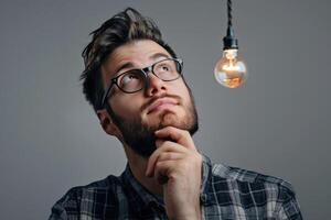 A man with glasses and a beard is thinking about something photo