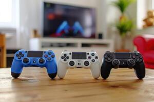 Three different colored controllers on a table in front of a television photo