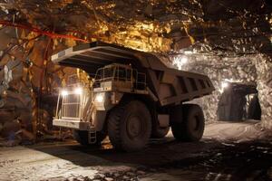A large dump truck in a mine with lights on photo