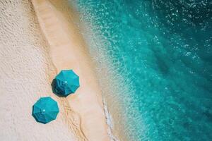 Two umbrellas on the beach with the ocean in the background photo