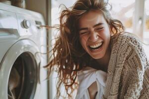 A woman laughing while she is in front of a washing machine photo