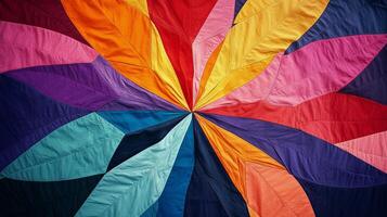 Vibrant textile design with multicolored leaf-like shapes radiating from a central point, showcasing a spectrum of colors photo