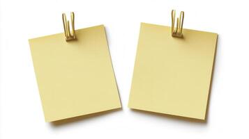 Two yellow sticky notes with clips on a white background photo