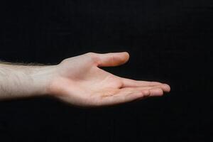A hand is holding something out to the side photo